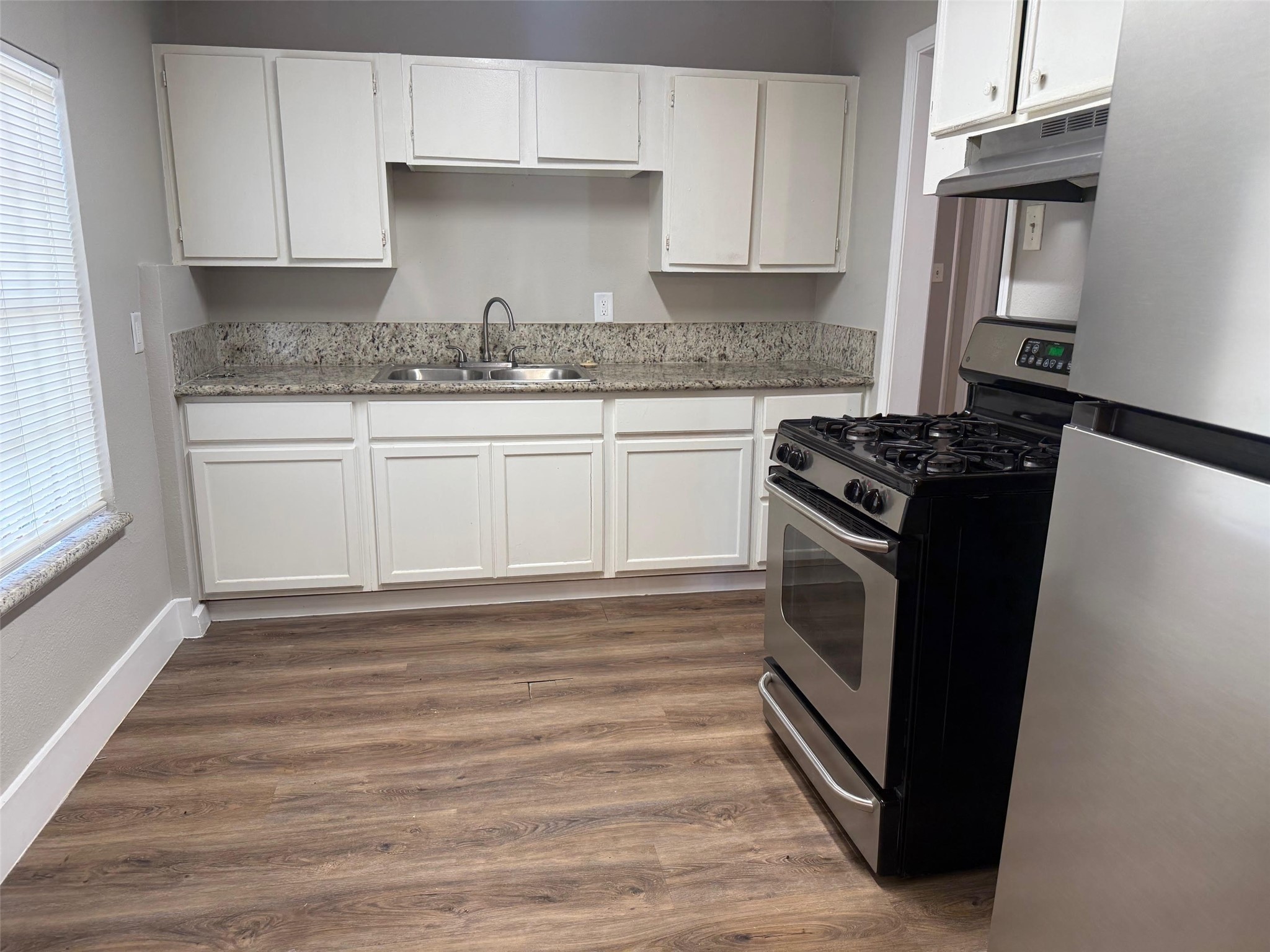 5933 Southgood Street Houston, TX 77033 - Photo 2 of 10 a kitchen with granite countertop a refrigerator stove and sink