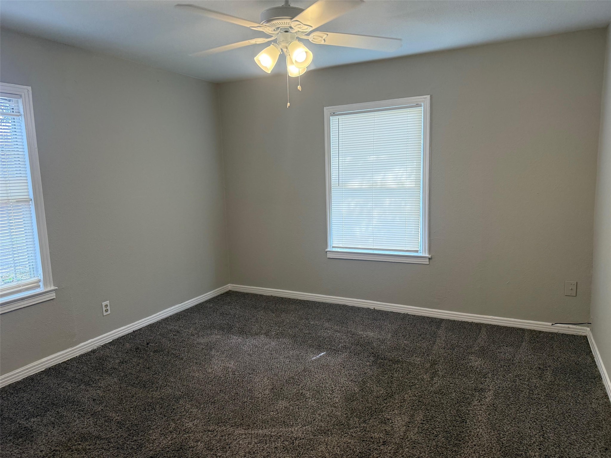 5933 Southgood Street Houston, TX 77033 - Photo 6 of 10 an empty room with windows and fan