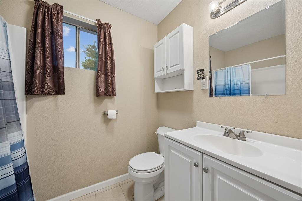 117 Moon Street Cleburne, TX 76033 - Photo 19 of 28 a bathroom with a sink toilet and mirror