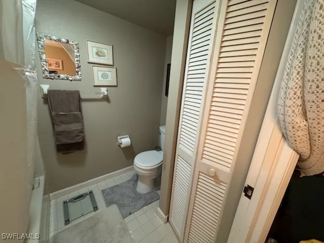 a bathroom with a toilet and a shower curtain