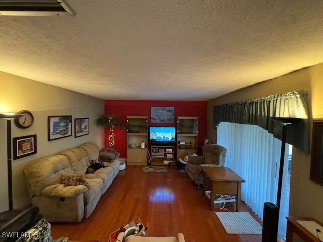 a living room with furniture and a flat screen tv with wooden floor