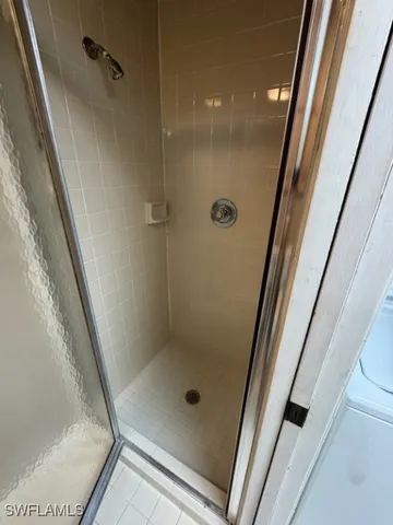 a bathroom with a glass door shower and toilet