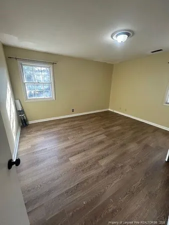 an empty room with wooden floor and a window