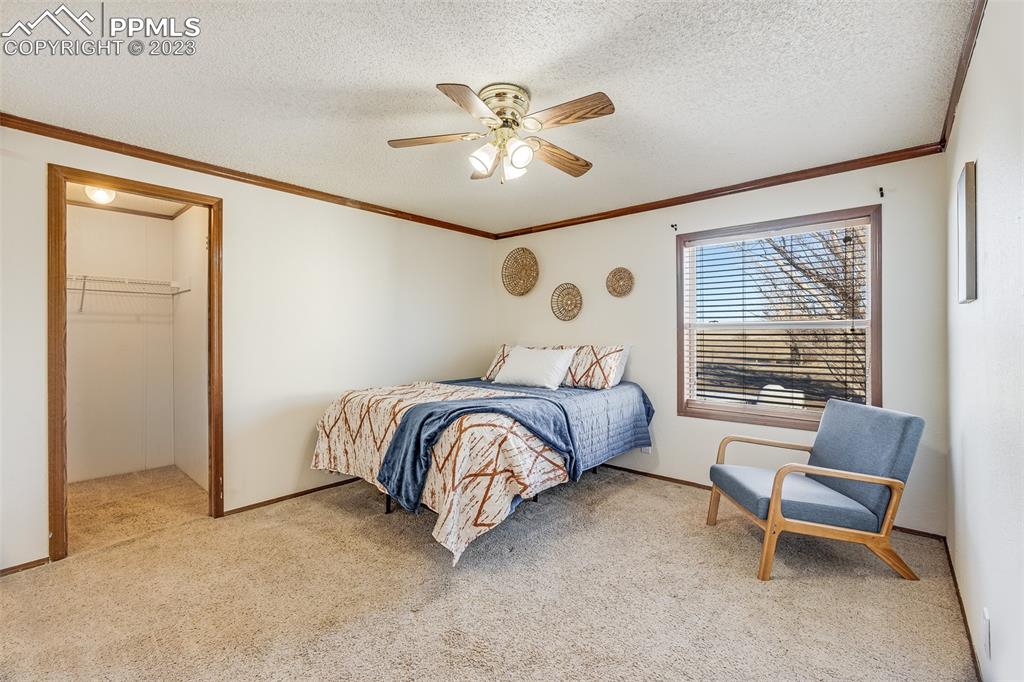 29550 Paint Mine Road Calhan, CO 80808 - Photo 22 of 33 a bedroom with a bed and a chandelier