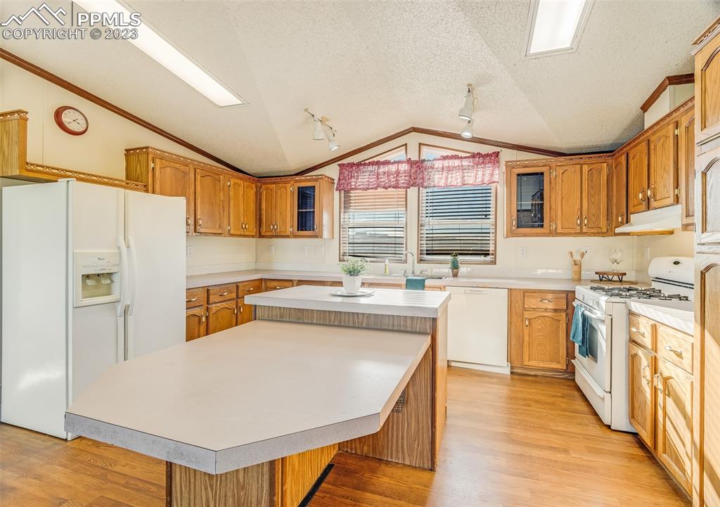29550 Paint Mine Road Calhan, CO 80808 - Photo 6 of 33 a kitchen with stainless steel appliances granite countertop a sink a stove a refrigerator a stove and island with wooden floor