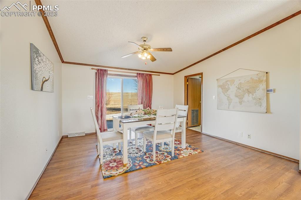 29550 Paint Mine Road Calhan, CO 80808 - Photo 8 of 33 a view of a dining room with furniture window and wooden floor