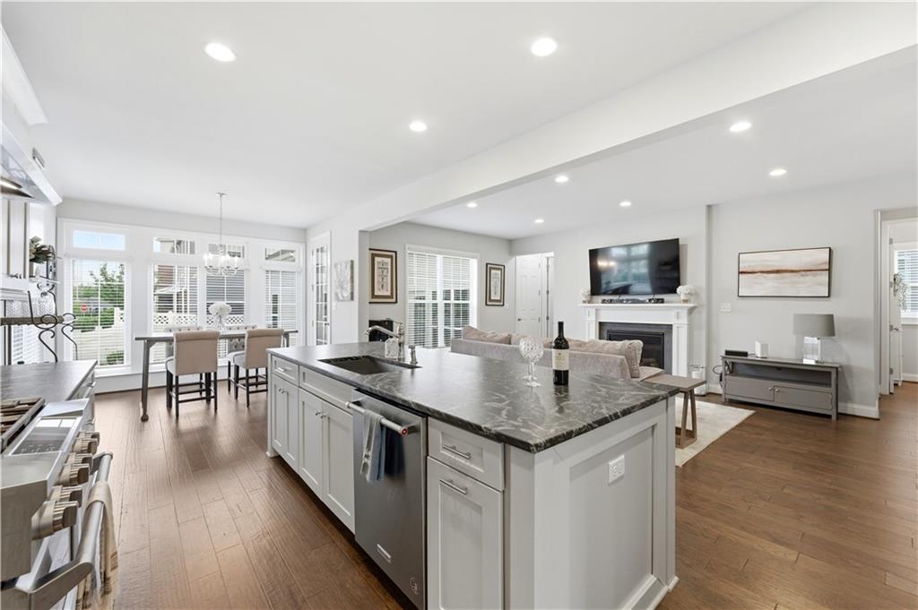 1502 Orion Road Bridgeville, PA 15017 - Photo 14 of 46 a kitchen with stainless steel appliances granite countertop a stove top oven a sink a dining table and chairs with wooden floor