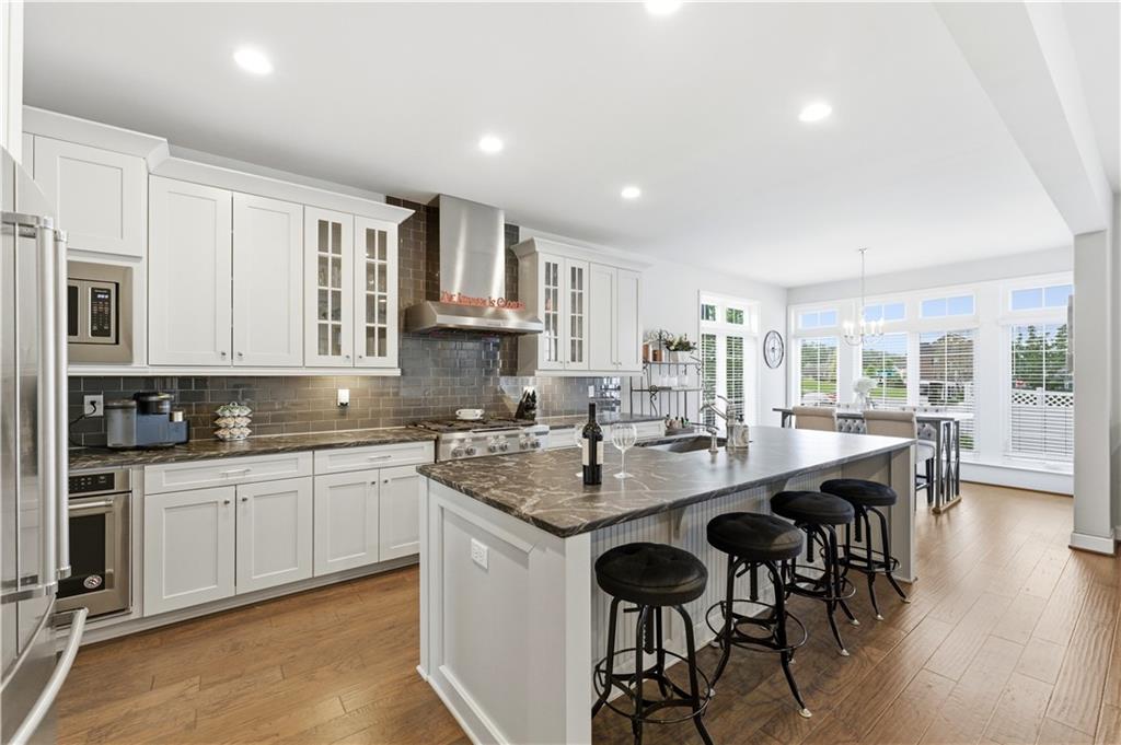 1502 Orion Road Bridgeville, PA 15017 - Photo 9 of 46 a kitchen with stainless steel appliances granite countertop a stove top oven a sink a refrigerator and white cabinets with wooden floor