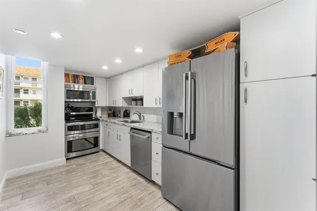 a kitchen with stainless steel appliances a refrigerator and a stove top oven