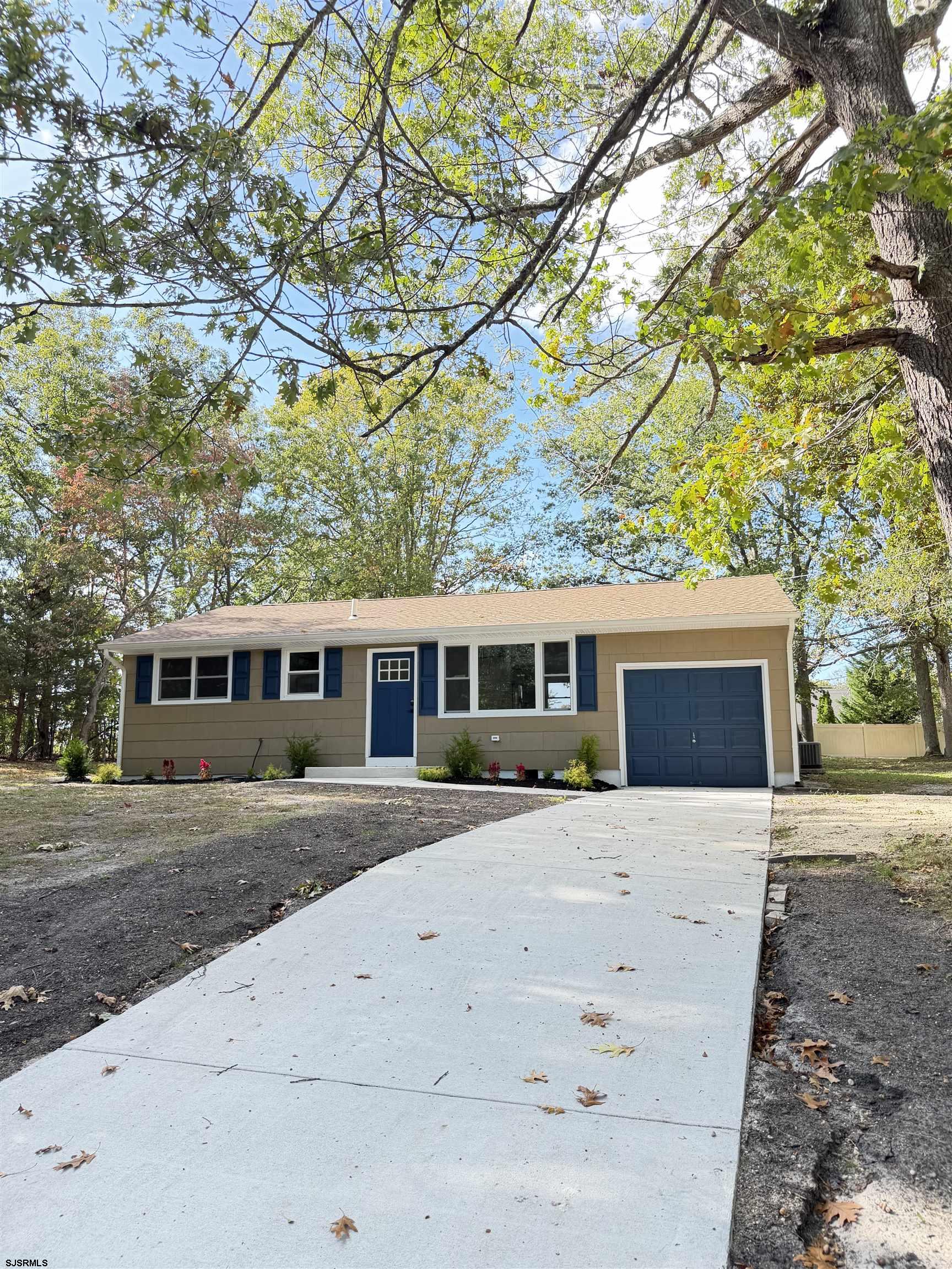 a front view of a house with a yard and trees