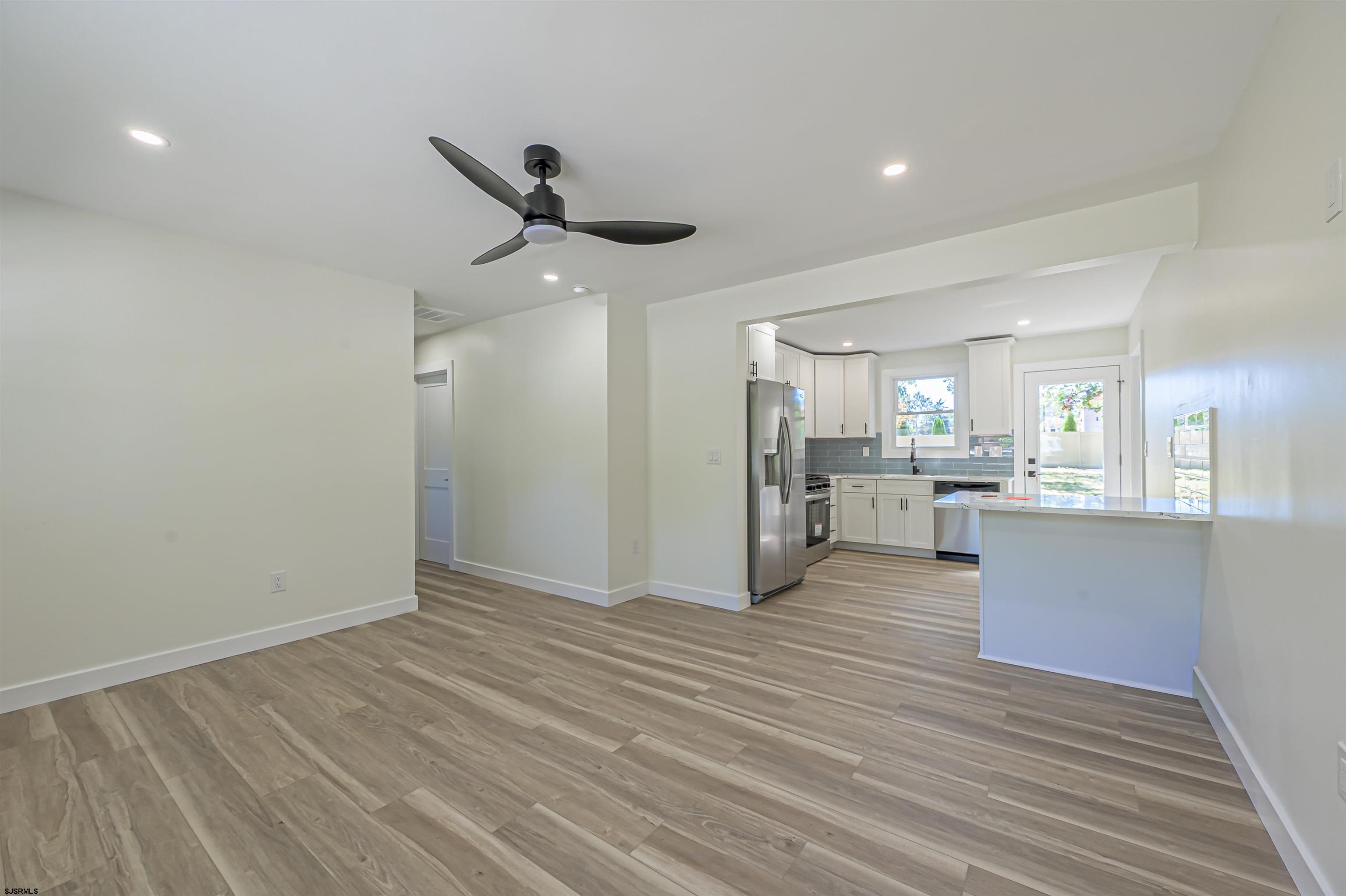 310 Sandy Lane Galloway Township, NJ 08205 - Photo 18 of 48 a view of an empty room and kitchen view with wooden floor