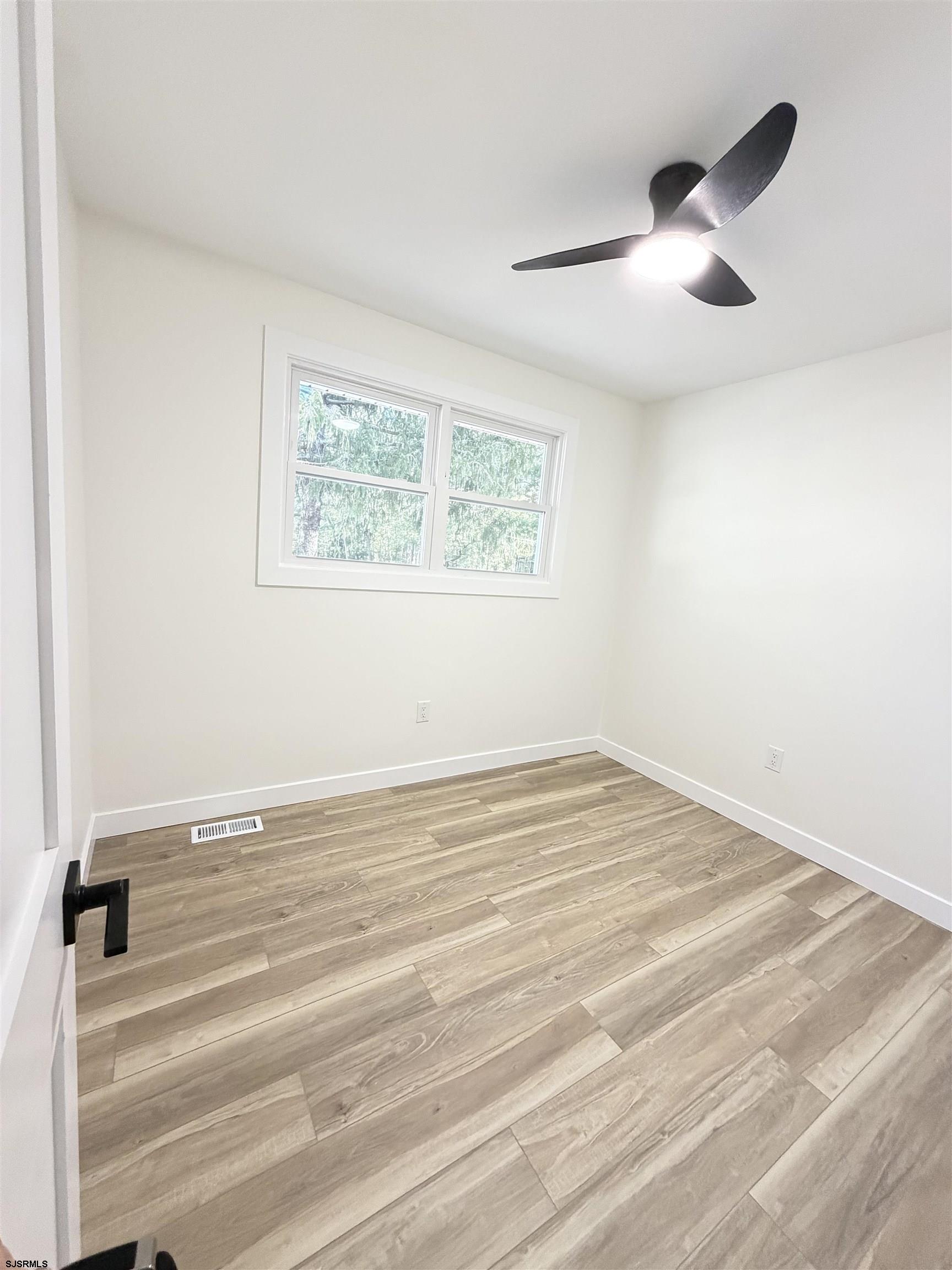 310 Sandy Lane Galloway Township, NJ 08205 - Photo 38 of 48 an empty room with wooden floor and windows