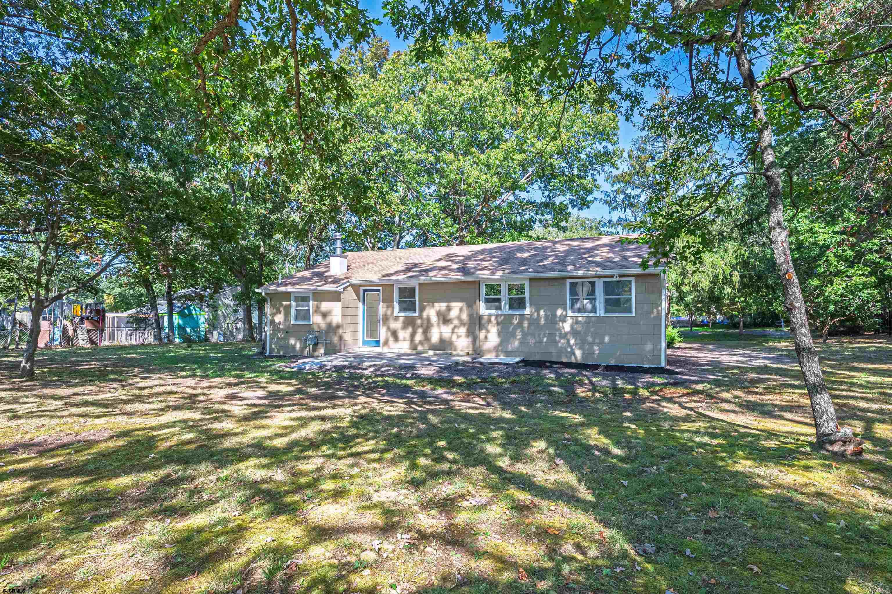 310 Sandy Lane Galloway Township, NJ 08205 - Photo 10 of 48 a view of a yard in front of a brick house with large windows