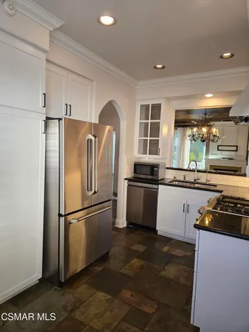 a kitchen with granite countertop a refrigerator stove and sink