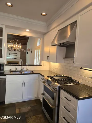 a kitchen with stainless steel appliances granite countertop a stove and a sink