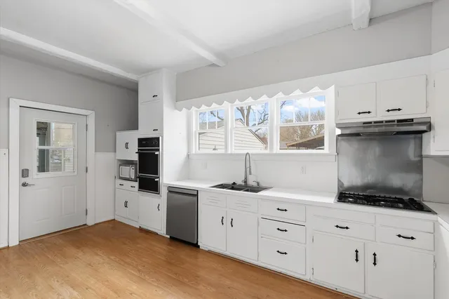 a kitchen with granite countertop a sink and cabinets
