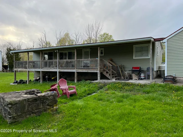 a view of a porch with furniture and a yard