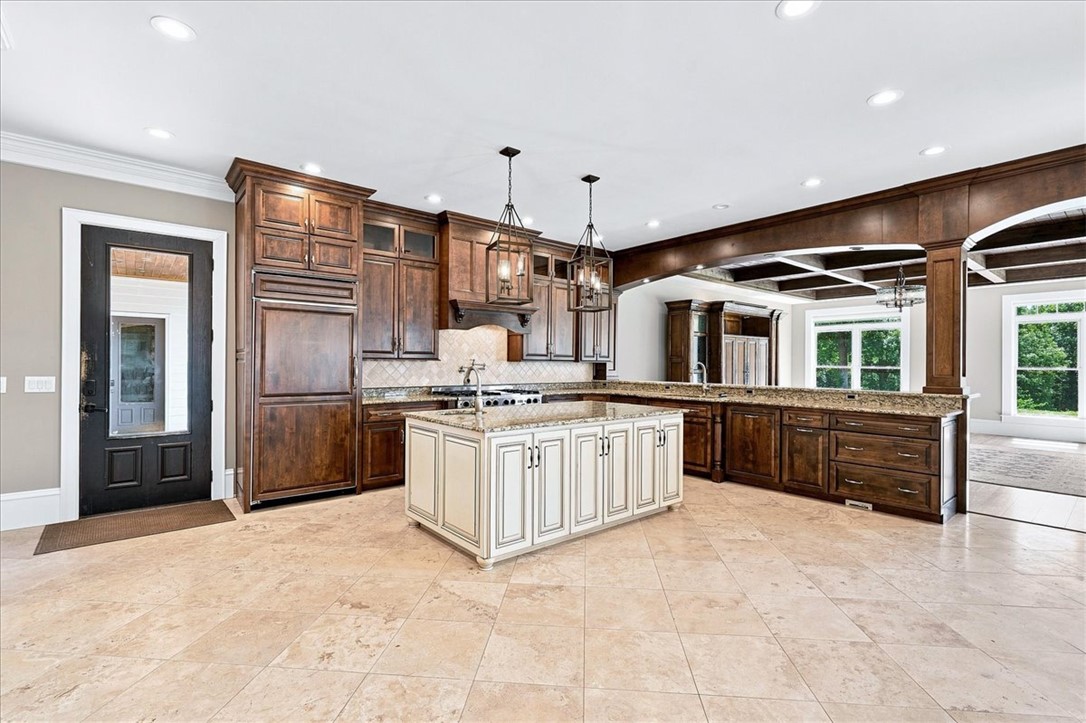 181 Sentell Road Williamston, SC 29697 - Photo 3 of 46 Rich wood cabinetry, central island, and travertine flooring ground this spacious, culinary space.