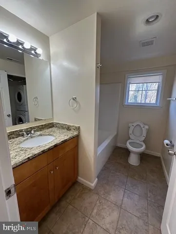 a bathroom with a granite countertop sink a toilet and a mirror