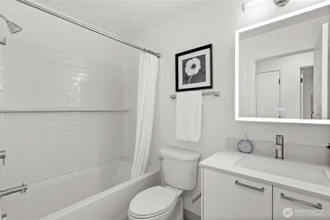 a bathroom with a granite countertop sink toilet a mirror and shower