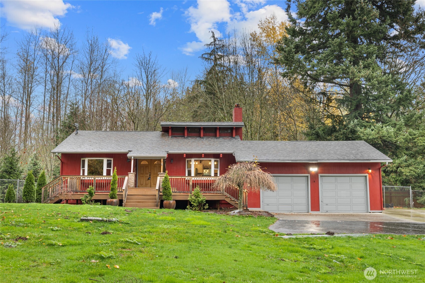 a front view of a house with a garden and trees