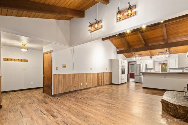 a view of an empty room with window and wooden floor