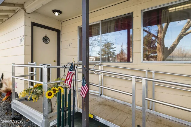 a view of a hallway with front door and wooden floor