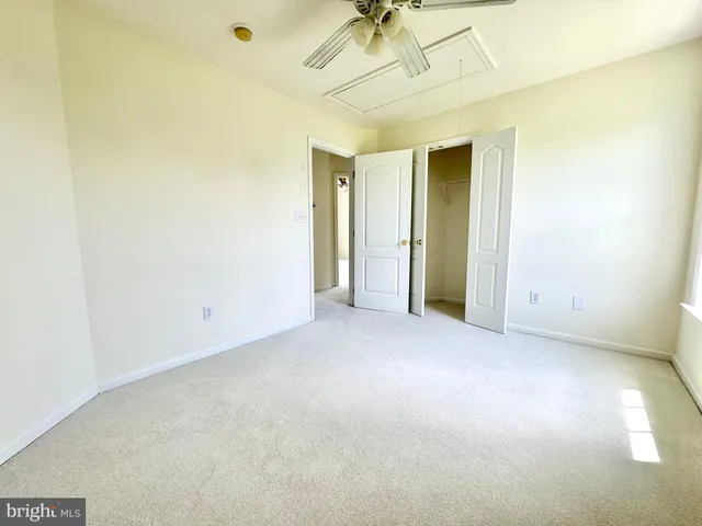 an empty room with a ceiling fan and a window
