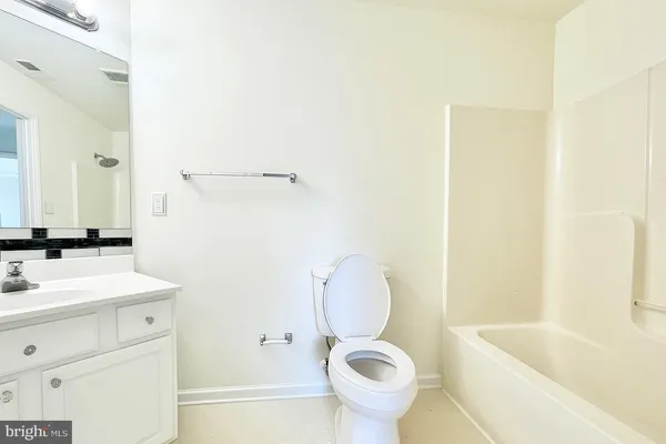 an empty room with a window and a ceiling fan