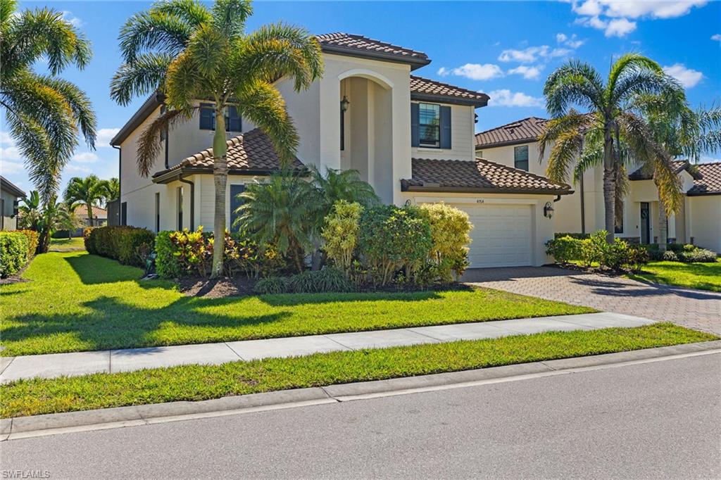 a front view of a house with a garden and plants