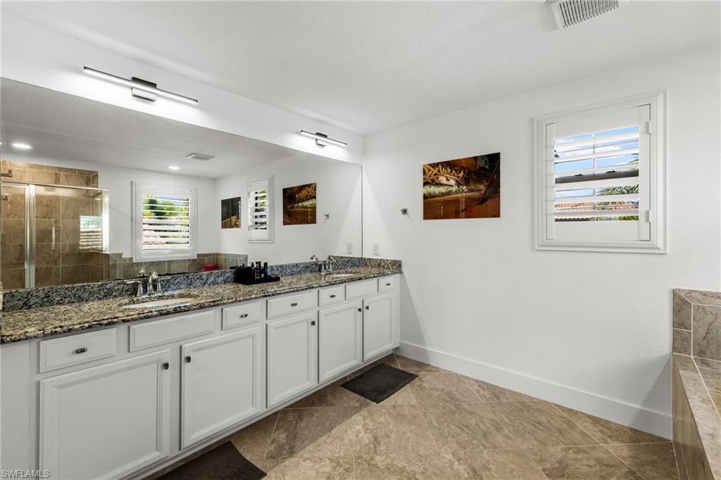 4764 Formosa Drive Naples, FL 34119 - Photo 17 of 32 a spacious bathroom with double sink and a mirror
