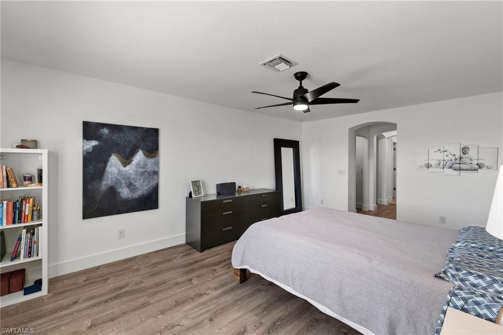 4764 Formosa Drive Naples, FL 34119 - Photo 18 of 32 a bedroom with a bed and a chandelier