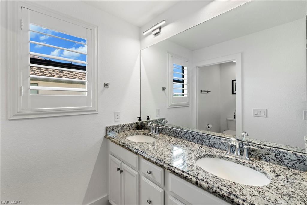 4764 Formosa Drive Naples, FL 34119 - Photo 20 of 32 a bathroom with a granite countertop sink and a mirror