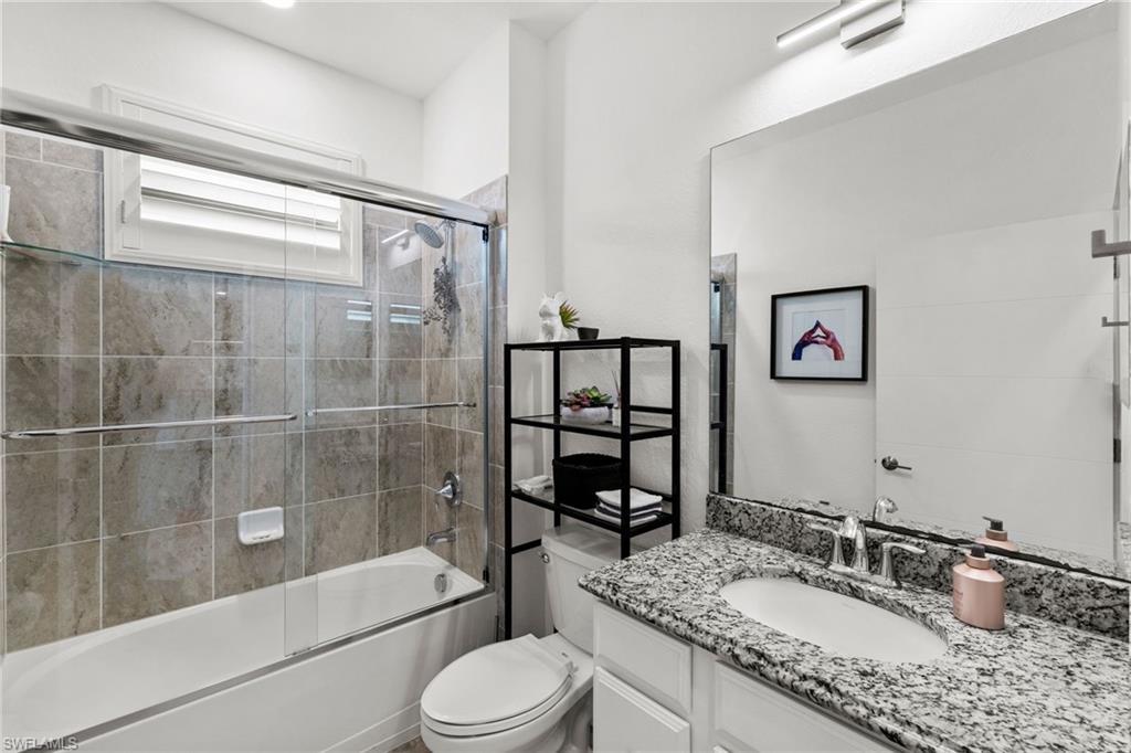 4764 Formosa Drive Naples, FL 34119 - Photo 22 of 32 a bathroom with a granite countertop sink toilet and shower