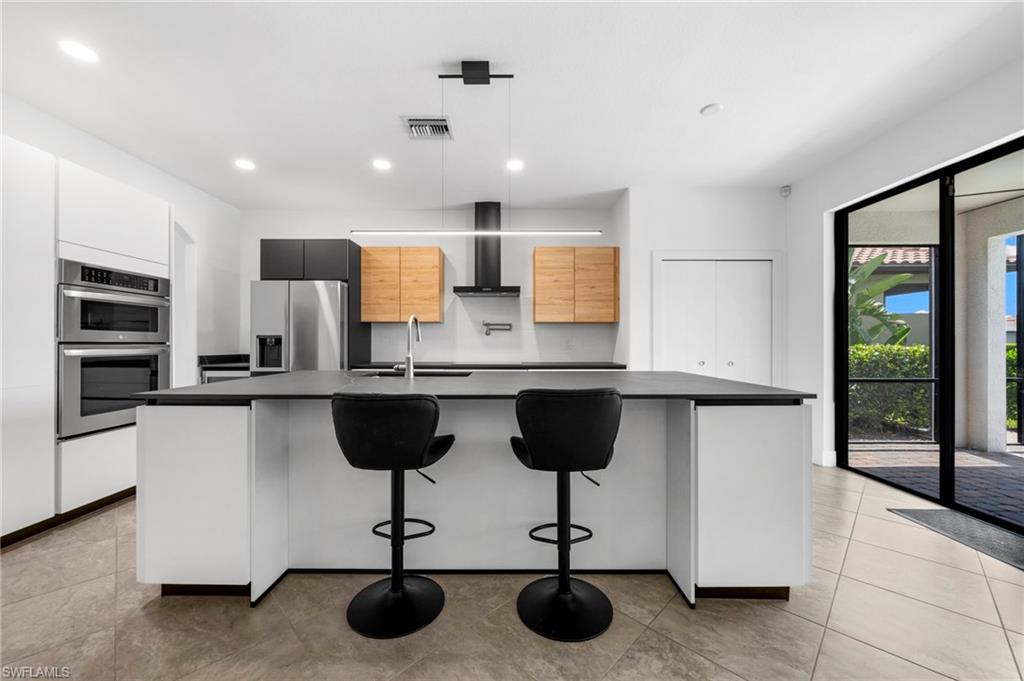 4764 Formosa Drive Naples, FL 34119 - Photo 5 of 32 a kitchen with a refrigerator and microwave