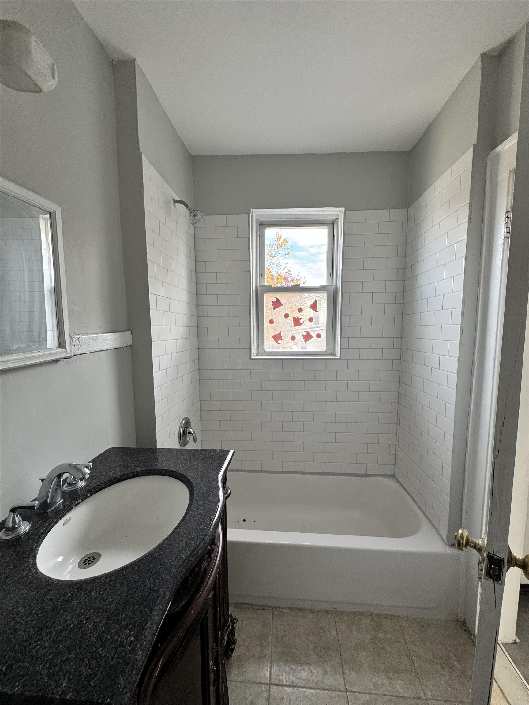 11 Westervelt Place, Unit 2 Irvington, NJ 07111 - Photo 2 of 6 a bathroom with a tub sink and mirror