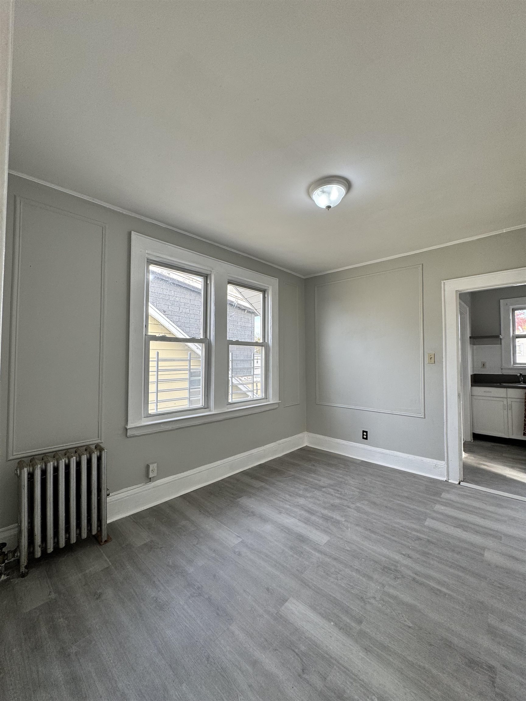 11 Westervelt Place, Unit 2 Irvington, NJ 07111 - Photo 3 of 6 an empty room with wooden floor and windows