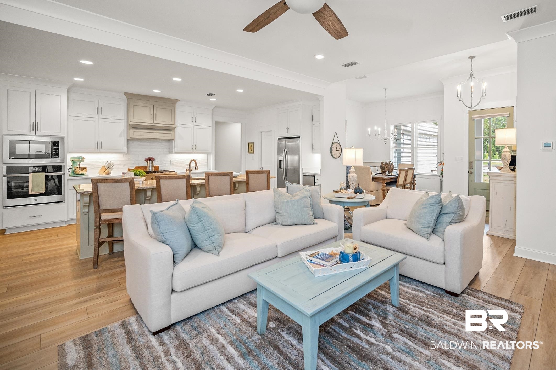 4601 Surrey Lane Orange Beach, AL 36561 - Photo 10 of 43 Living room with light wood-type flooring, ceiling fan with notable chandelier, and sink