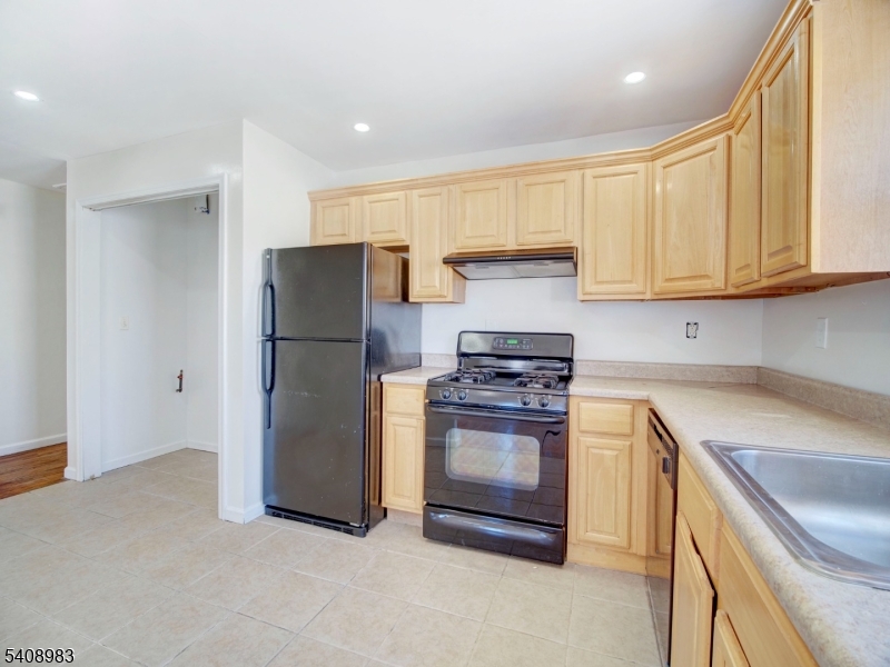 91 William Street East Orange, NJ 07017 - Photo 4 of 10 a kitchen with stainless steel appliances granite countertop a refrigerator sink and stove