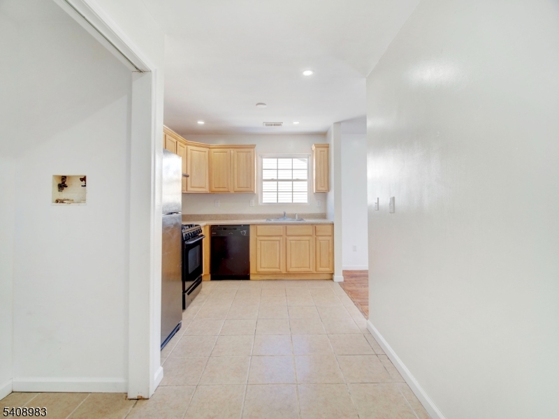 91 William Street East Orange, NJ 07017 - Photo 5 of 10 a view of a kitchen with a refrigerator a sink and dishwasher cabinets