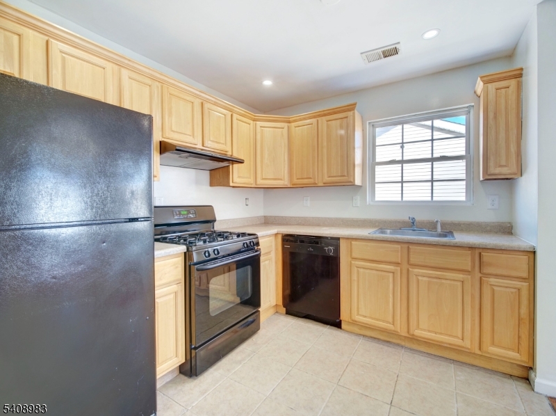 91 William Street East Orange, NJ 07017 - Photo 6 of 10 a kitchen with cabinets appliances and a window