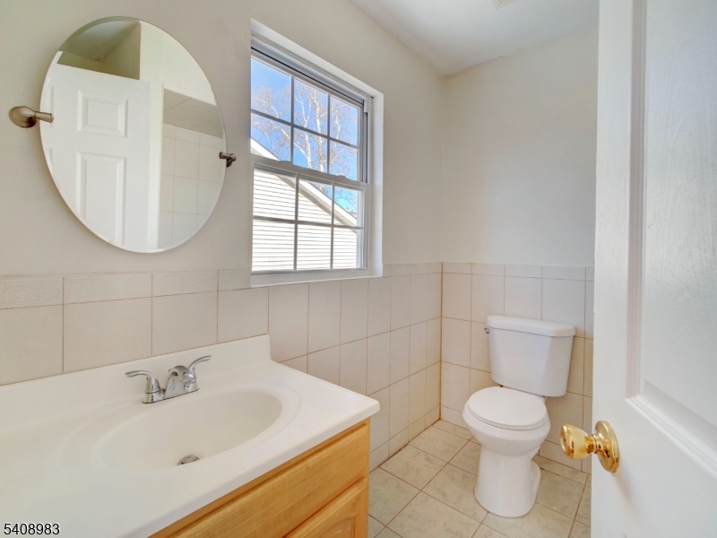91 William Street East Orange, NJ 07017 - Photo 7 of 10 a bathroom with a sink a toilet and a mirror