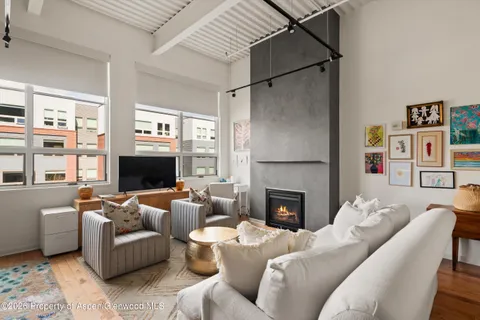 a living room with furniture a flat screen tv and a fireplace