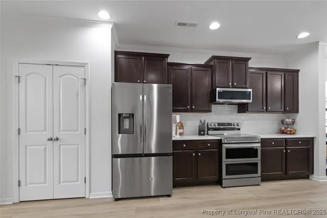 a kitchen with stainless steel appliances a refrigerator and a stove top oven