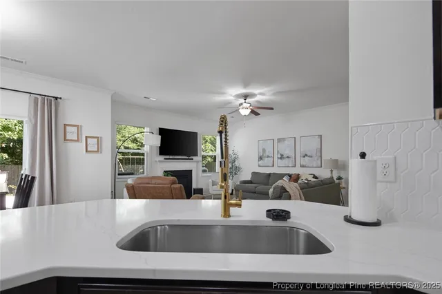 a kitchen with a sink and a large mirror with wooden floor