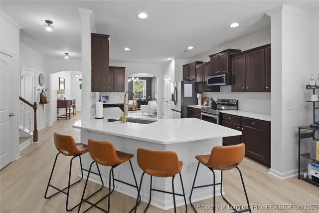 a kitchen with stainless steel appliances kitchen island granite countertop a sink and cabinets