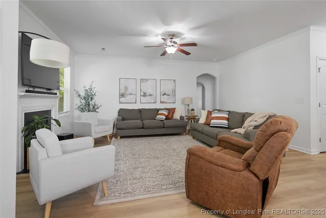 a living room with furniture a fireplace and a flat screen tv