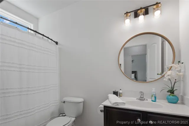 a bathroom with a sink mirror vanity and toilet