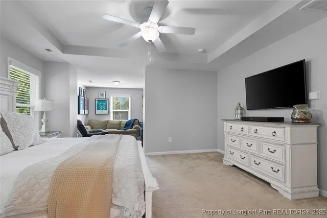 a bedroom with a bed television on dresser and a flat screen tv