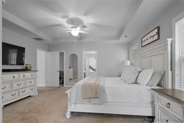 a bedroom with a large bed and a flat tv screen on dresser
